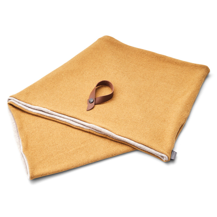 Gillio Winterschal ,reversible Senfgelb und Beige. Der Schal liegt mit braunem Lederbamdverschluss darauf. Weisser Hintergrund#farbe_mustard-beige